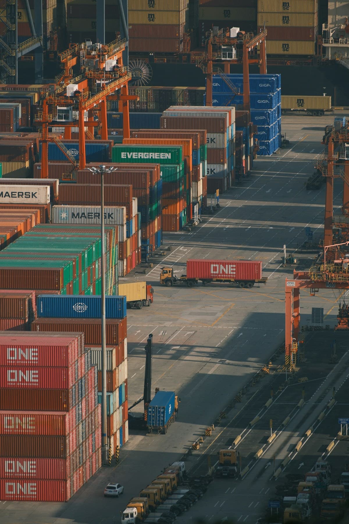 Shipping container yard with cranes and trucks